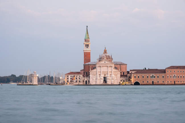 Erstaunliche antike Gebäude steht in der Nähe von ruhigem Wasser auf der Straße von Venedig — Stockfoto
