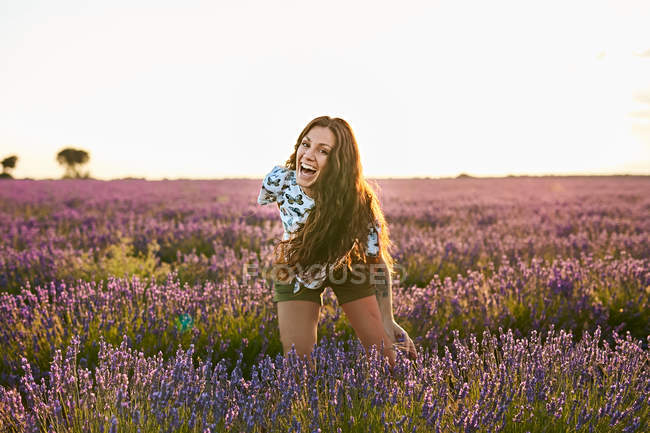 Молода жінка сміється між фіолетовим лавандовим полем — стокове фото