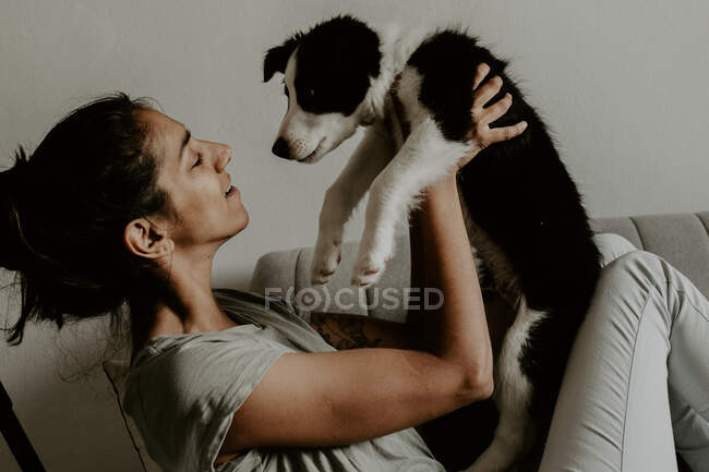 Menina adolescente com filhote de cachorro bonito no sofá — Fotografia de Stock