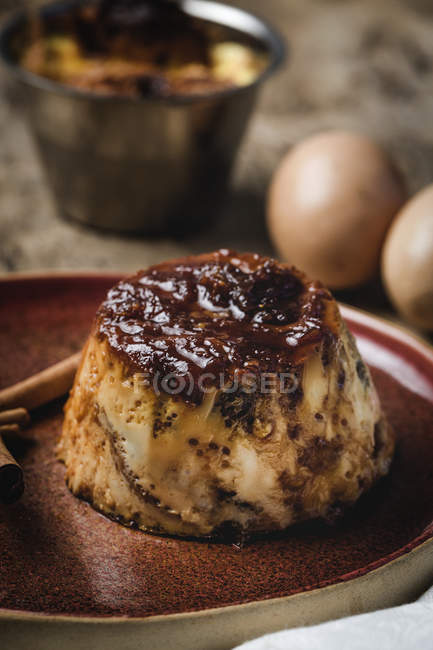 Primo piano di delizioso budino fatto in casa sul piatto sul tavolo in legno rustico — Foto stock