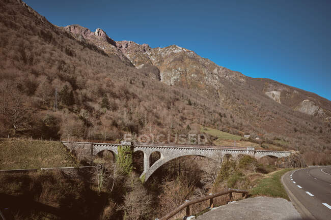 Bridge above trees near hills — Stock Photo