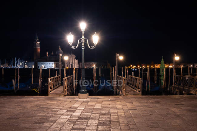 Яскравий світильник стоїть на тротуарі біля каналу в прекрасну ніч у величній мерзлоті. — стокове фото