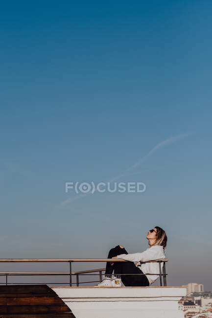 Mulher atraente sentado no telhado — Fotografia de Stock