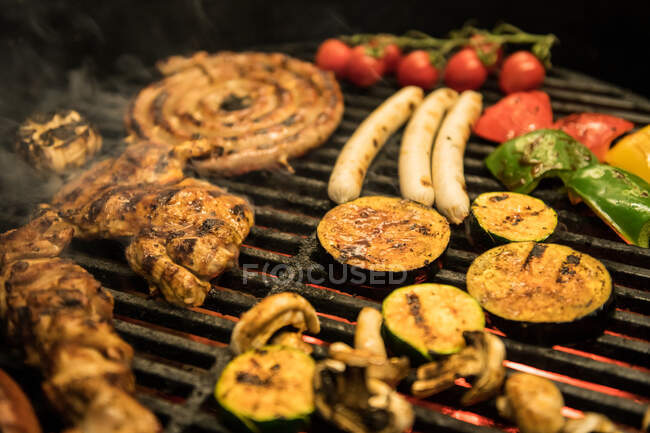 Closeup tranches de légumes assortis et la friture de viande sur le gril chaud — Photo de stock