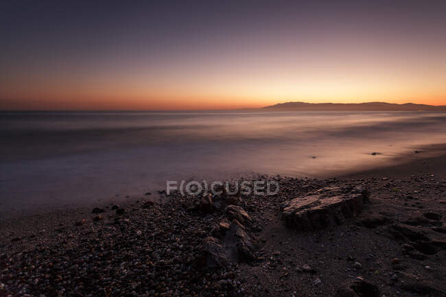 Incrível costa rochosa de mar calmo durante o magnífico pôr do sol — Fotografia de Stock