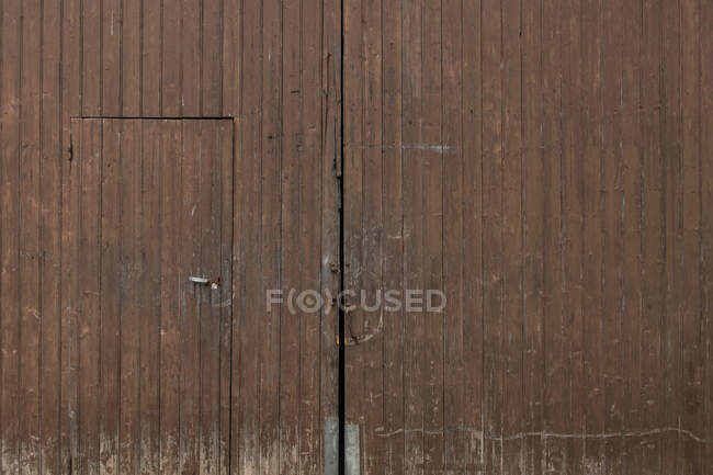 Construcción antigua con puerta de madera marrón en un pueblo rural en los Pirineos - foto de stock