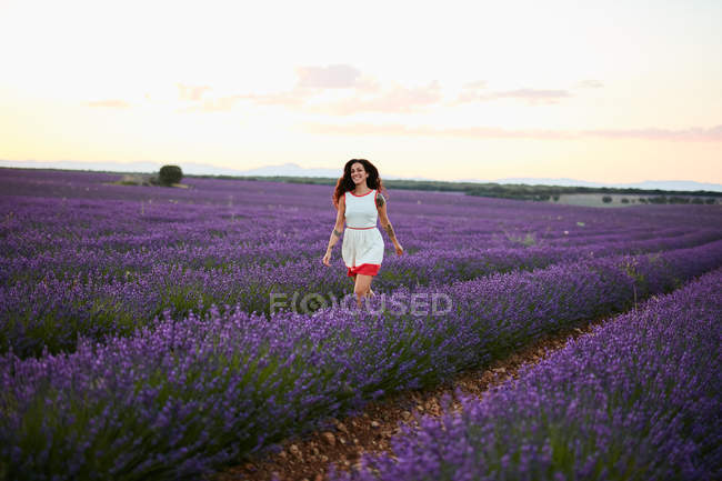 Giovane donna che corre tra il campo di lavanda viola — Foto stock