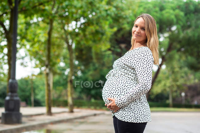 Беременная привлекательная женщина на улице — стоковое фото