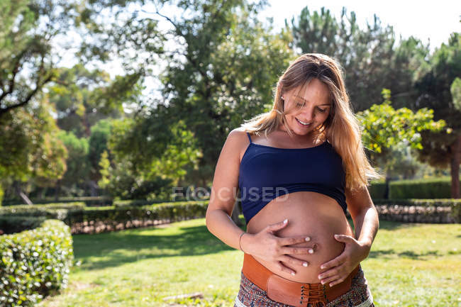 Sorridente donna attraente incinta nel parco — Foto stock
