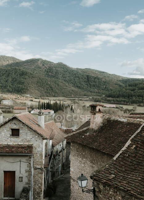 Vista panoramica della città antica vicino ad alte colline con foresta e cielo blu con nuvole nei Pirenei — Foto stock