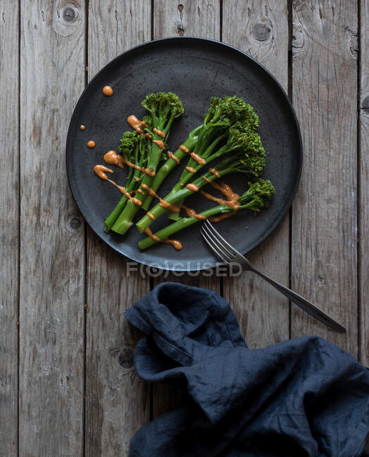 De cima tiro de garfo e guardanapo deitado perto da placa com brócolis verde saudável — Fotografia de Stock