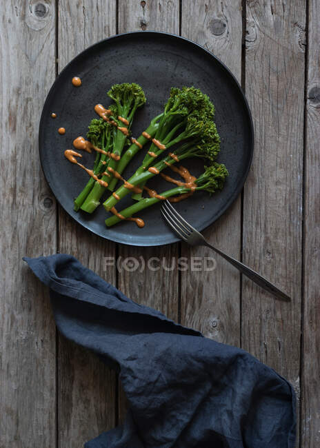 З верхнього кадру виделки й серветки, що лежить біля тарілки з здоровим зеленим брокколі. — стокове фото