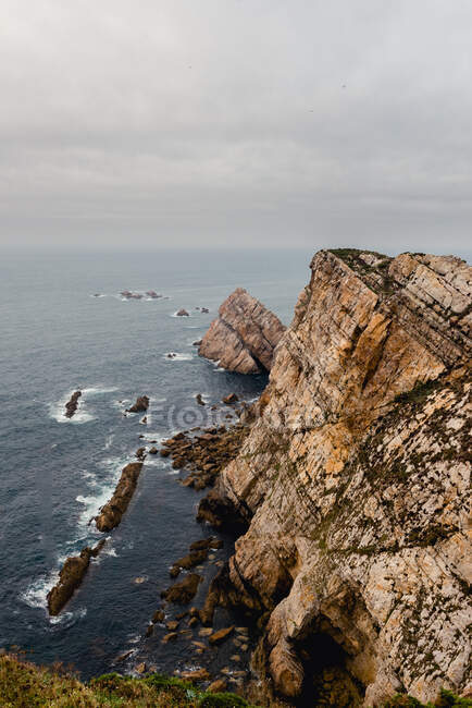 Грубый скала около моря в пасмурный день — стоковое фото