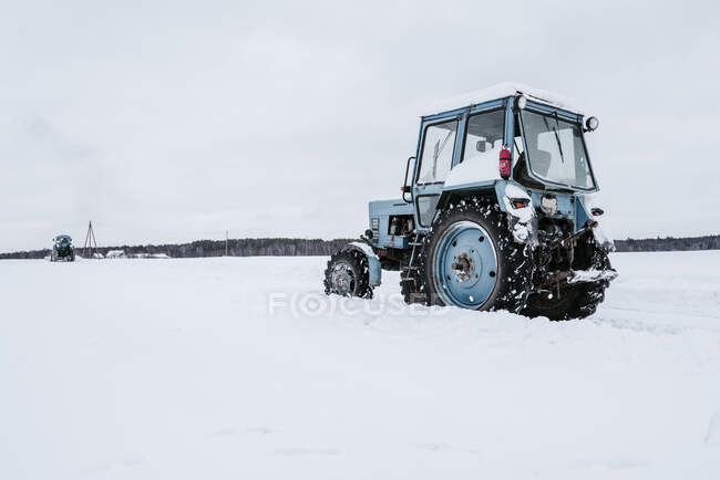 Tratores que limpam a neve do campo — Fotografia de Stock