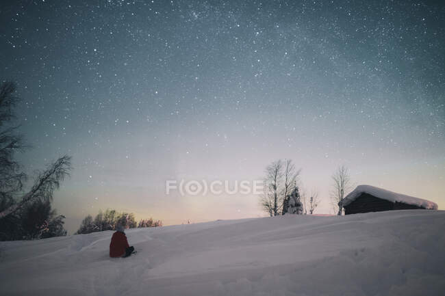 Rückansicht einer Person, die den schönen Nachthimmel in der arktischen Landschaft bewundert — Stockfoto