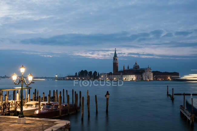 Vista nocturna de las góndolas sobre la ola y San Giorgio Maggiore, Venecia, Italia - foto de stock