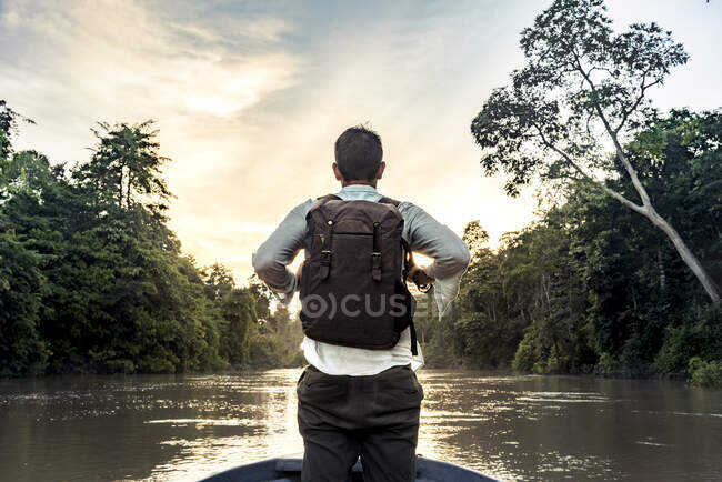 Voltar visão jovem cara com mochila em pé no arco do navio navegando no rio entre a floresta exótica em praias na Malásia — Fotografia de Stock