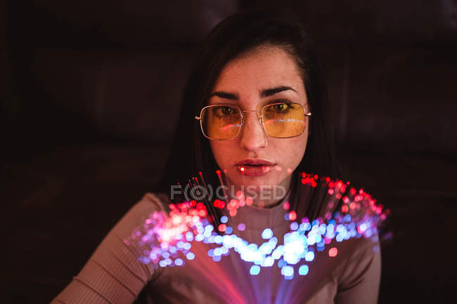 Giovane donna con le luci delle fate nel buio — Foto stock