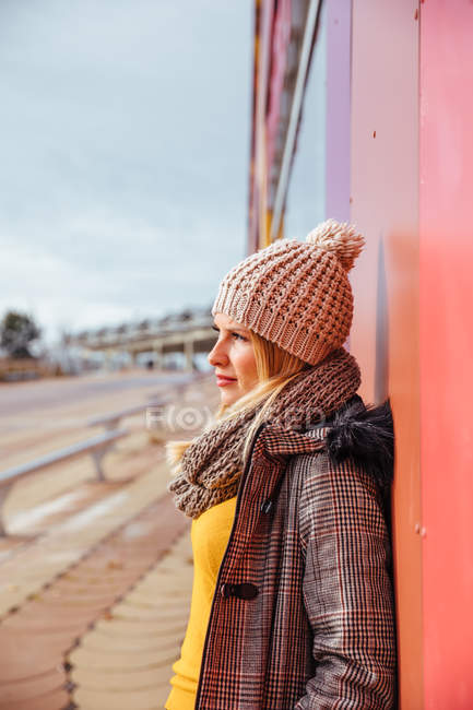 Blonde fille appuyé sur un mur coloré — Photo de stock