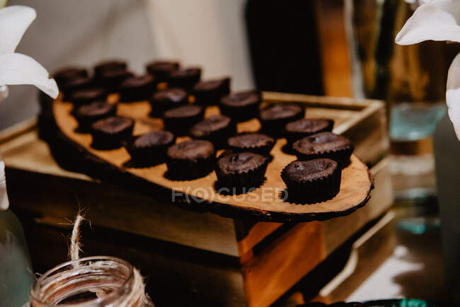 Deliciosos muffins de chocolate fresco na placa de madeira na caixa — Fotografia de Stock