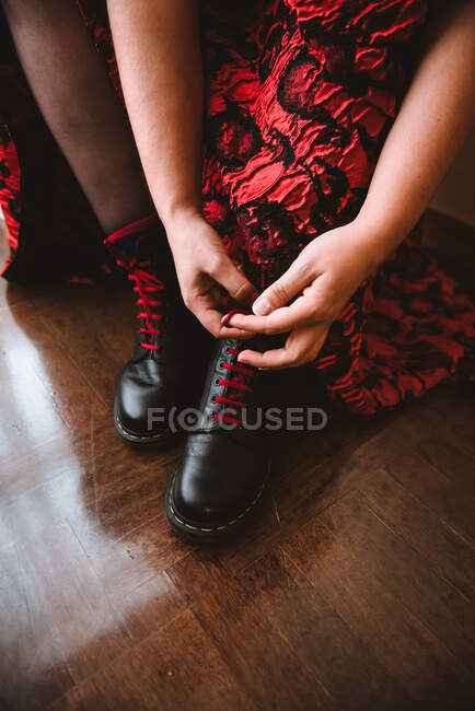 Femme en robe lacer des bottes — Photo de stock
