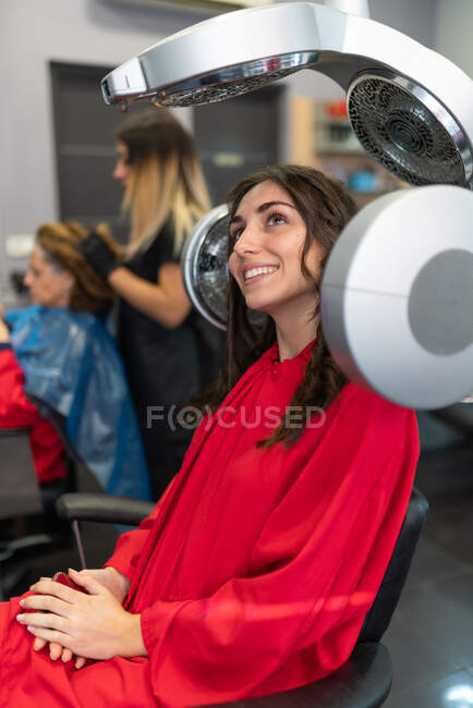 Vista lateral de los cabellos de secado alegres en el salón de peluquería - foto de stock
