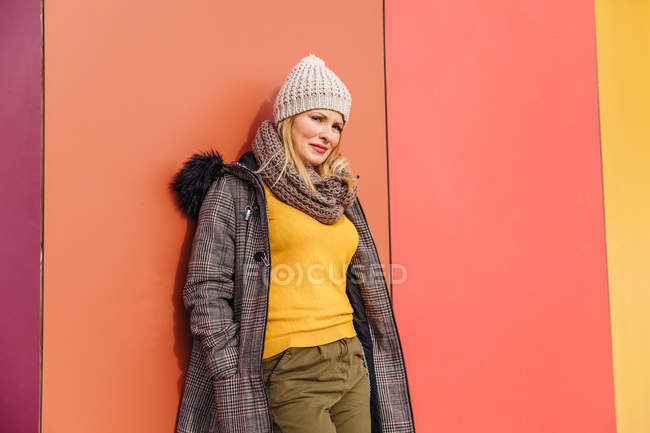 Menina loira se apoiando em uma parede colorida — Fotografia de Stock