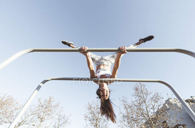 Woman training on parallel bars on street — Stock Photo