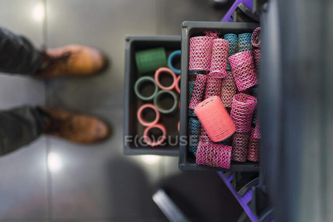 From above collections of different hair rollers placed on trays in shelves in hairdressing salon — Stock Photo