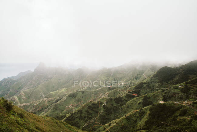 Amazing drone view of thick fog over majestic rough hills in magnificent nature — Stock Photo