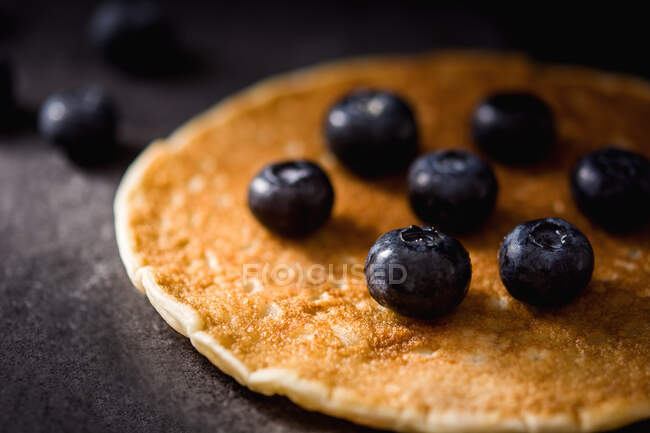 Nahaufnahme köstlicher Pfannkuchen mit reifen Blaubeeren auf dunkelgrauer Tischplatte — Stockfoto