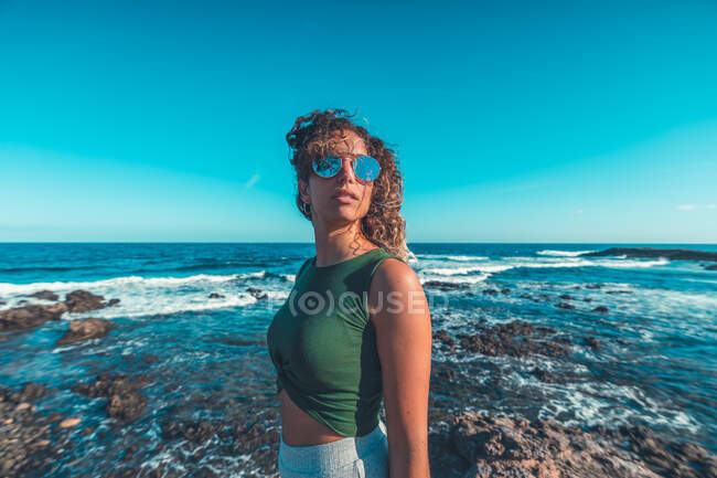 Стильная женщина, стоящая у моря — стоковое фото