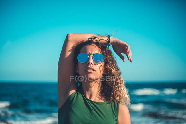 Mujer con estilo de pie cerca del mar - foto de stock