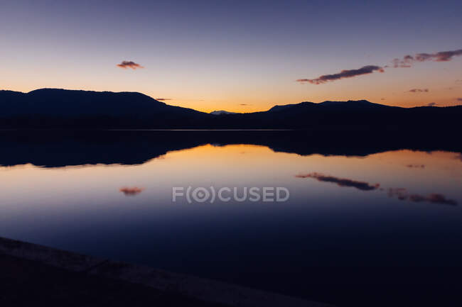 Pittoresca vista del meraviglioso cielo al tramonto sopra la cresta della montagna e l'acqua tranquilla — Foto stock
