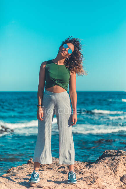 Donna elegante in piedi vicino al mare — Foto stock