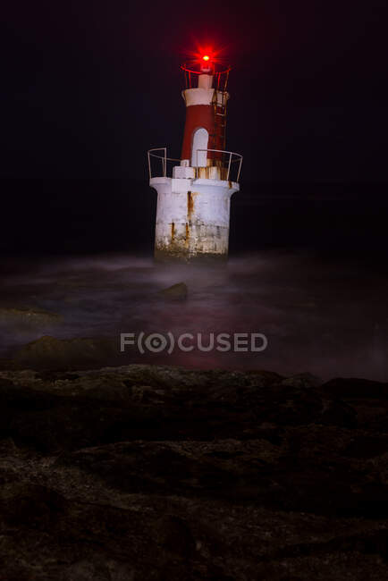 Lighthouse on rocky coastline — Stock Photo