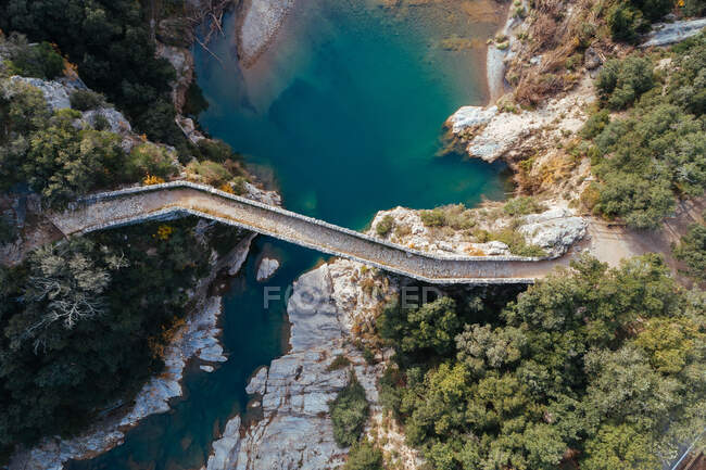 Panorama mozzafiato drone di antico ponte sul tranquillo fiume blu nella splendida campagna — Foto stock