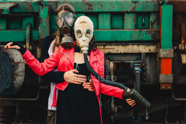 Long haired guy and stylish lady in gas masks — Stock Photo