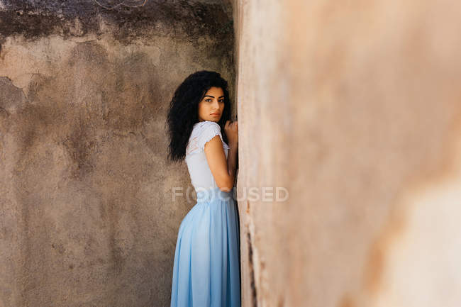 Красивая женщина рядом с потрепанной стеной — стоковое фото