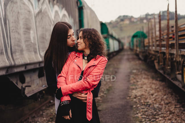 Lungo dai capelli uomo abbracciare e baciare donna vicino treno — Foto stock