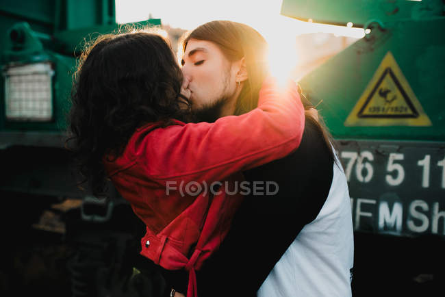 Homem de cabelos compridos abraçando e beijando mulher perto de trem — Fotografia de Stock