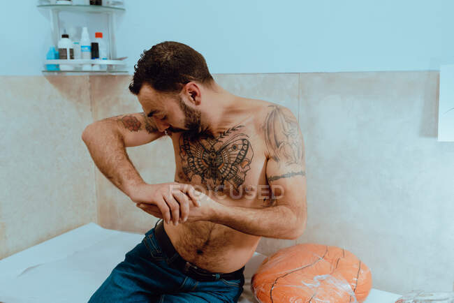 Jeune homme barbu torse nu avec des tatouages — Photo de stock