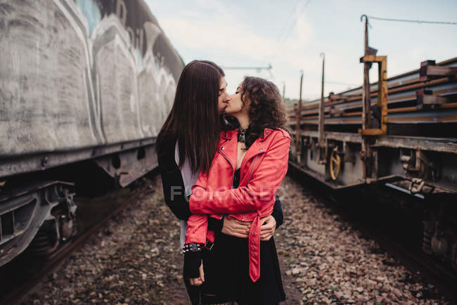 Homem de cabelos compridos abraçando e beijando mulher perto de trem — Fotografia de Stock