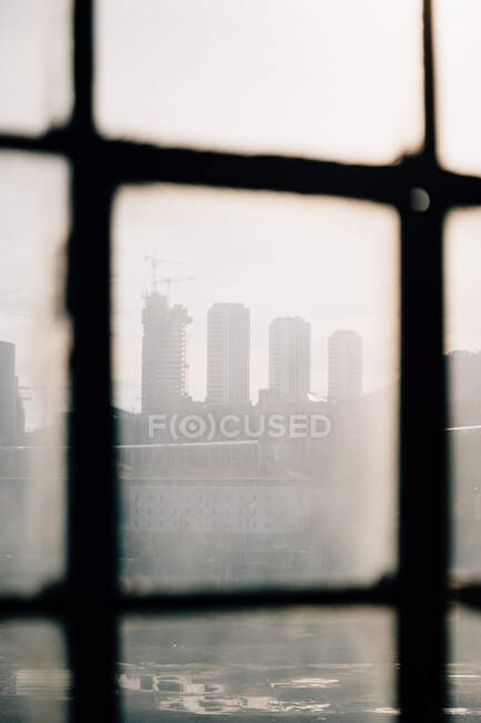 Vue de la ville par fenêtre sale — Photo de stock