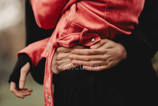 Imagem cortada de cara abraçando elegante senhora magra em jaqueta rosa no fundo borrado — Fotografia de Stock