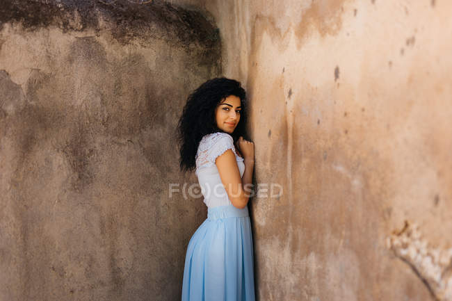 Красивая женщина рядом с потрепанной стеной — стоковое фото