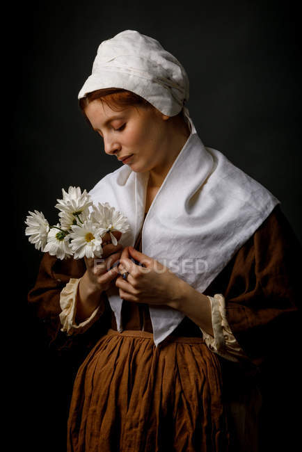 Medieval maid holding bunch of flowers. — Stock Photo