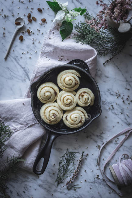 Top view of uncooked cinnamon rolls in pan on table. — Stock Photo