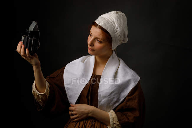 Medieval maid taking selfie with vintage photo camera. — Stock Photo