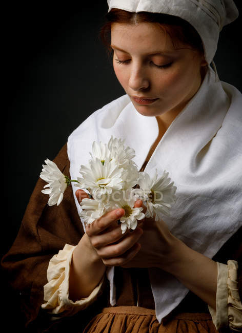 Medieval young maid holding bunch flowers. — Stock Photo